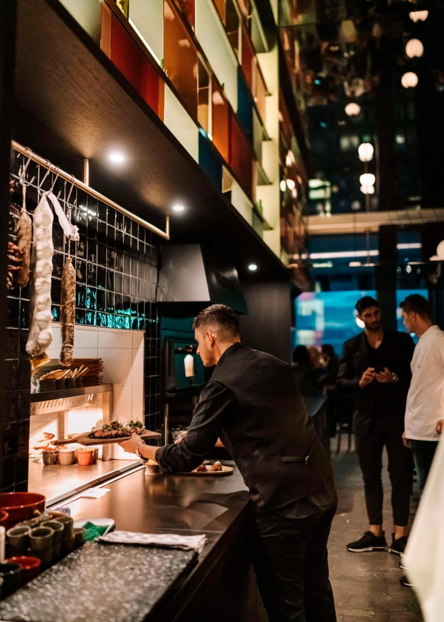 ホテル アンダーズ ミュンヘン シュヴァビンガー トーア ア コンセプト バイ ハイアット エクステリア 写真 Chef preparing food at a restaurant